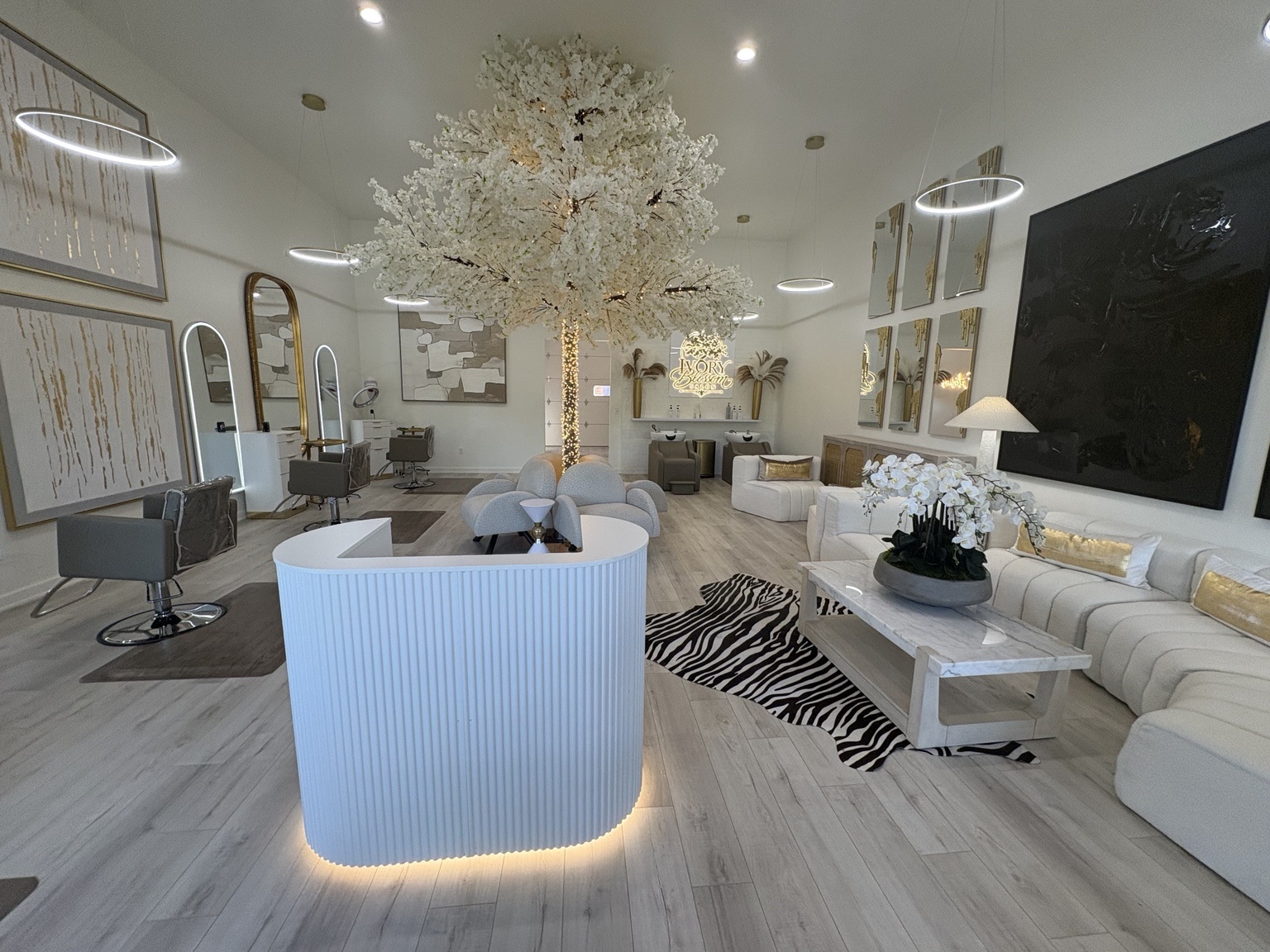 Reception desk, styling chairs, illuminated blossom tree and ivory lounge at Ivory Blossom Salon in Broken Arrow